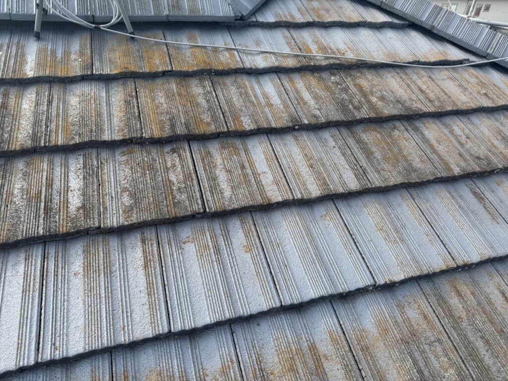 塗装前のモニエル瓦屋根。瓦の表面に色の変化や茶色い付着物が見られる状態