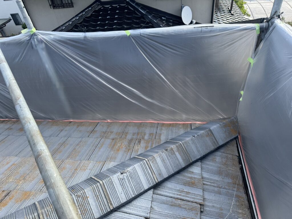 モニエル瓦屋根の端部に飛散防止用シートを設置した施工前の状態