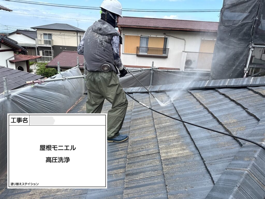 職人が高圧洗浄機でモニエル瓦屋根の表面を洗浄している施工風景